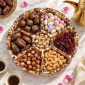 Divided wooden serving plate from above with chocolates and nuts for Eid