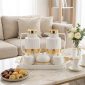 White and gold thermos set on a living room table ready for guests with maamoul