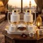 White and gold thermos set on a Ramadan iftar table with dates and lantern